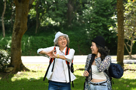 Joyful senior women talking each other while walking at nature park. Retirement, people and outdoor activity concept.の写真素材