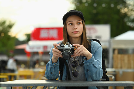 Happy caucasian woman in hipster outfit spending free time outdoors, walking in the city street on beautiful day.の写真素材