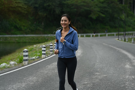 Active sporty woman jogging at the park in the morning. Healthy lifestyle, workout and wellness...