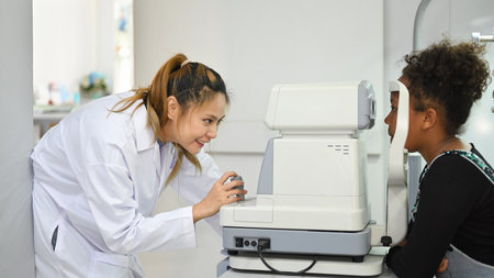 Teenage woman checking eyesight on auto refractor in ophthalmologist clinic. Eye health check and...