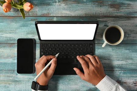Aerial view of businessman hands typing on wireless keyboard of digital tablet.の写真素材
