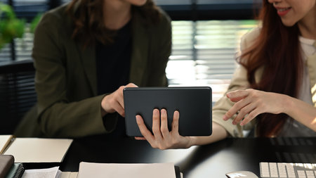 Cropped shot of two business partner using digital tablet and discussing over new business project...