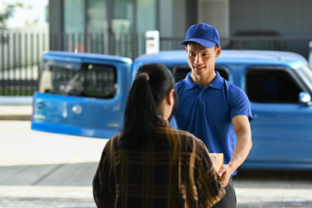 Delivery man giving a cardboard box to woman customer at home. Delivery service, delivery home and shipping concept.の写真素材