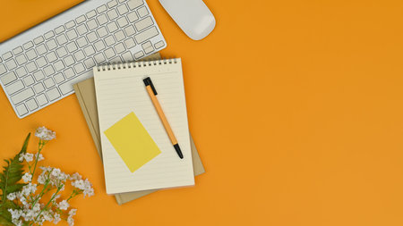 Flat lay blank notepad, pen, keyboard and mouse on yellow background. Copy space for your advertise text.の写真素材