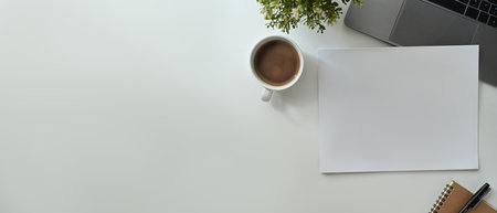 Flat lay, Top view of blank paper, cup of coffee, laptop and notebook on office desk. Copy space for advertise text.の写真素材