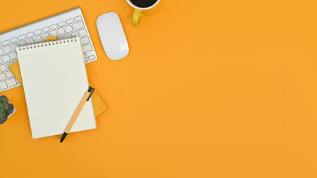 Top view of notepad, keyboard, mouse and coffee cup on yellow background. Copy space for your text.の写真素材