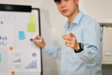 Selective focus, businessman pointing fingers at camera while presenting business data on...