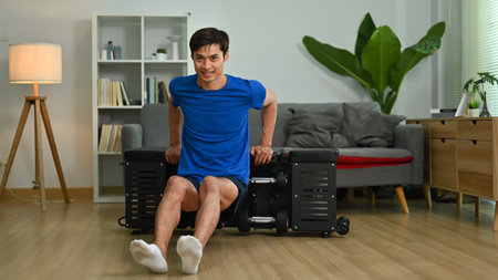 Full length of strong man exercising on sports bench at home. Home fitness and healthy lifestyle...