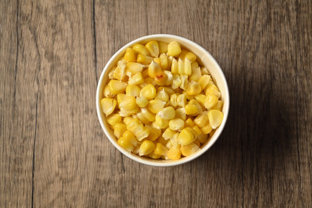 A cup of hot boiled corn on rustic wooden table. Healthy organic nutrition and vegetarian food concept.の写真素材
