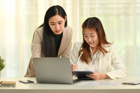 Two professional partners discussing business plan, collaborating on project development in corporate office.の写真素材