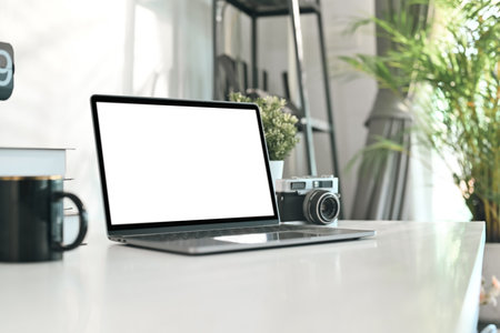 Creative designer workplace with laptop computer, retro camera and coffee cup on white table.の写真素材