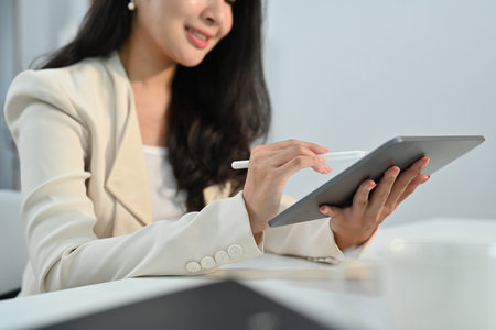 Smiling professional businesswomen using digital tablet working on investment and marketing projects at modern office.の写真素材