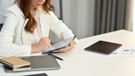 Cropped shot of female accountant working bookkeeping documents, checking financial data at office.の写真素材