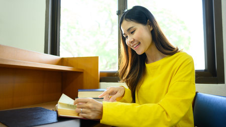 Peaceful woman reading interesting book, preparing for exam in library. People, knowledge and...