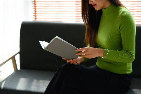 Peaceful young woman sitting on couch and reading book. People, leisure and lifestyle concept.の写真素材