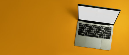 Laptop computer with white empty screen on yellow background with copy space for your advertise...