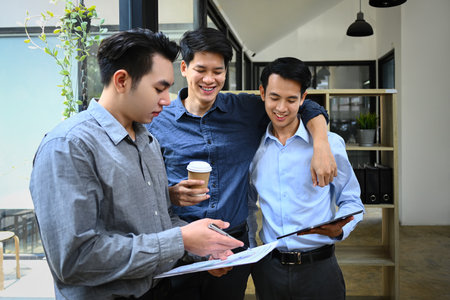 Group of coworker discussing project or sharing news during coffee break in office.の写真素材