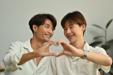 Cheerful young gay couple making heart with their hands. LGBT, love and lifestyle relationship concept.の写真素材