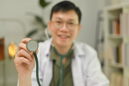 Select focus on hands of doctor holding stethoscope and looking at camera. Healthcare and medical concept.の写真素材