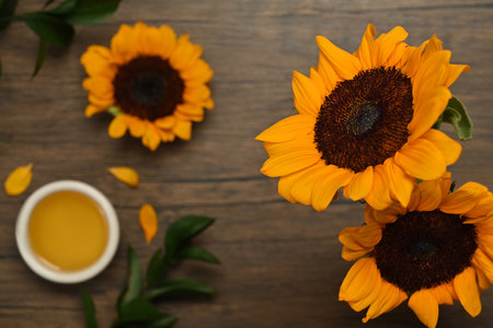 Bowl of sunflower seed oil and sunflower on rustic table. Agriculture, organic product, healthy oils, food.の写真素材