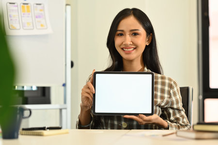 Beautiful businesswoman hands holding and showing digital tablet with empty screen for advertising...