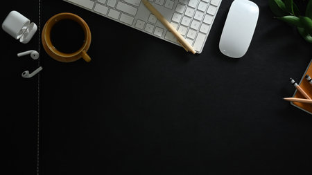 Top view of keyboard, cup of coffee and earphones on black office desk. Copy space for your text.の写真素材