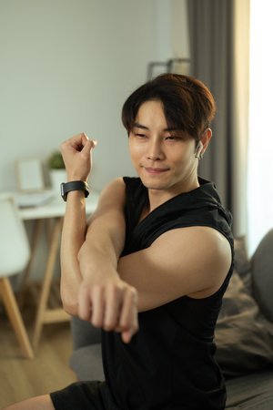 Shot of sportsman stretching exercise, preparing for morning workout at home. Healthy lifestyle concept.の写真素材