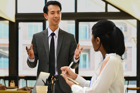 Confident businessman explaining project details, talking about company strategy and business plan during meeting.の写真素材