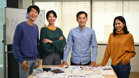 Image of professional developer team standing at co working space and smiling confidently to camera.の写真素材
