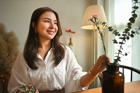 Gorgeous millennial woman florist creating beautiful bouquet in her floral shop. Small business concept.の写真素材
