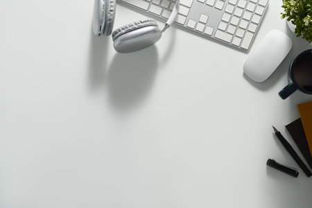 White office desk with headphone, keyboard, notebook and coffee cup. Top view with copy space for your text.の写真素材