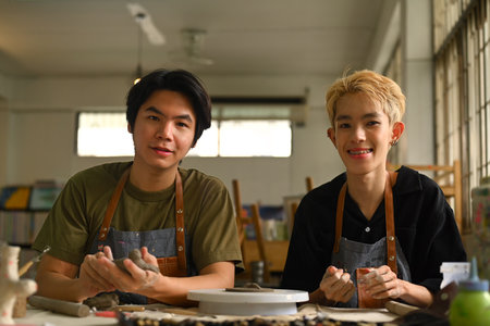 Image of ceramics art teacher and student sitting in pottery workshop. Indoors lifestyle activity,...