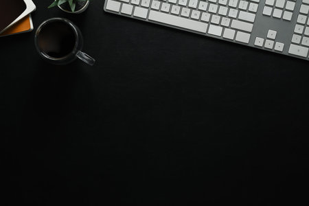 Top view of keyboard, cup of coffee and book on black leather. Copy space for your text.の写真素材