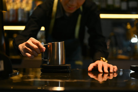 Close up of a young male barista weighing coffee beans on the electronic scales at coffee shop.の写真素材