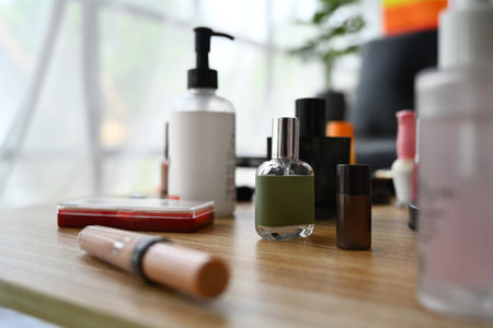 Closeup view of skincare product, lotion bottle, round mirror and makeup brushes on dressing table.の写真素材