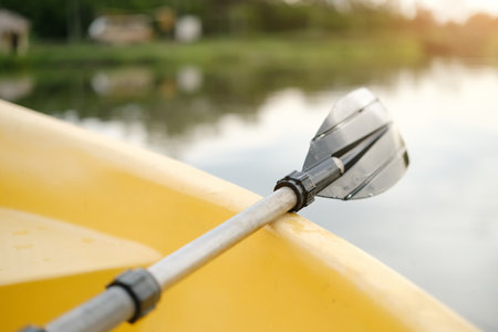 A small yellow boat boat with paddle floating on calm water sunrise. Solitude, calmness and relaxation.の写真素材