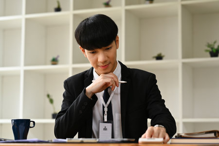 Asian man investment advisor wearing formalwear working in modern office.の写真素材