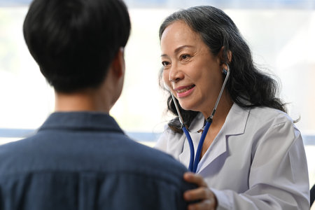 Mature doctor using stethoscope to checking heart and lungs of patient. Medical, consultation,...