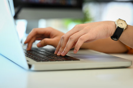 Unrecognizable woman hands typing on laptop keyboard, working in office or browsing information.の写真素材