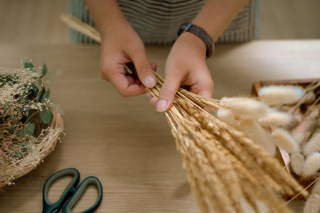 Cropped shot of florist making a bouquet of dried flowers at her workstation. Small business concept.の写真素材