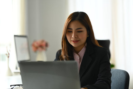 Beautiful asian woman entrepreneur working on investment and marketing projects at modern office.の写真素材