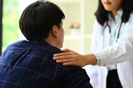 Psychologist comforting and supporting man patient at medical appointment. Psychotherapy and mental health concept.の写真素材