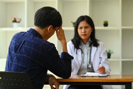 Male patient having consultation with psychologist at medical appointment. Psychotherapy and mental health concept.の写真素材