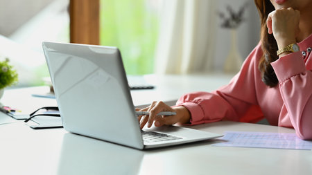 Cropped shot of female investment advisor chatting with client online, communicating on internet via laptop computer..の写真素材