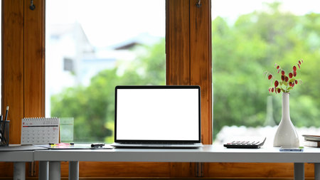 Home office interior , laptop computer with blank screen and office supplies on white table..の写真素材