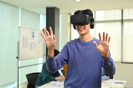 Young Creative man wearing VR headset having virtual reality experience, start up team discussing...