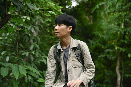 Attractive female hiker with backpack trekking in forest, exploring nature. Traveling, trekking and adventure concept.の写真素材