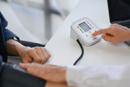 Doctor measuring blood pressure male patient at clinic. Hypertension, Health care concept.