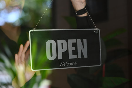 Man coffee shop or restaurant owner turning Open sign on the entrance door.の写真素材
