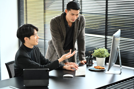 Handsome young businessman explaining project details, talking about company strategy with his coworker..の写真素材